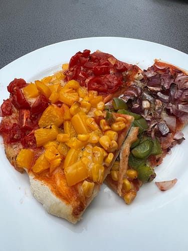 Regenbogen-Pizza auf Teller